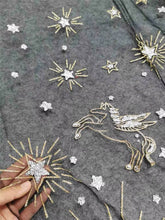 Load image into Gallery viewer, a close-up view of a grey fabric with gold and silver star and unicorn designs. The fabric appears to be a sheer material, with the stars and unicorn appearing to be embroidered onto the fabric.