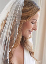 Load image into Gallery viewer, A woman with long, wavy blonde hair wearing a white veil with a beaded trim, smiling at the camera.
