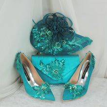 Load image into Gallery viewer, A pair of turquoise high-heeled shoes with intricate floral embellishments, a matching turquoise handbag, and a matching turquoise hat with a similar floral design.
