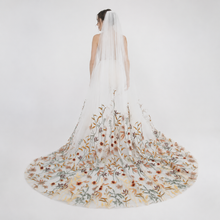 Load image into Gallery viewer, A woman wearing a long, white wedding dress with a long, flowing veil.
