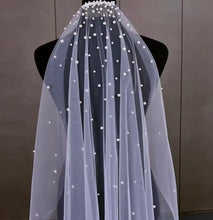 Load image into Gallery viewer, A mannequin wearing a white veil with small white pearls on it.
