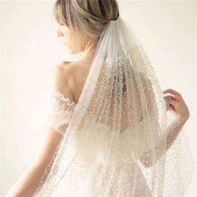 Load image into Gallery viewer, A woman wearing a white wedding dress with a long, sheer veil.
