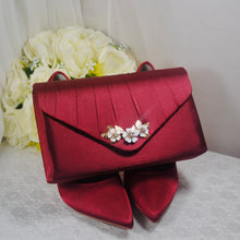 Load image into Gallery viewer, a red clutch bag with flowers on it
