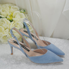 Load image into Gallery viewer, A pair of blue high-heeled shoes with a strap, placed on a white surface next to a bouquet of white roses.
