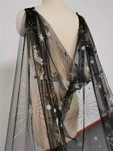 Load image into Gallery viewer, A mannequin wearing a black and gold sheer dress with a starry pattern.
