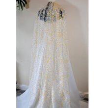 Load image into Gallery viewer, a white and yellow dress hanging on a wall
